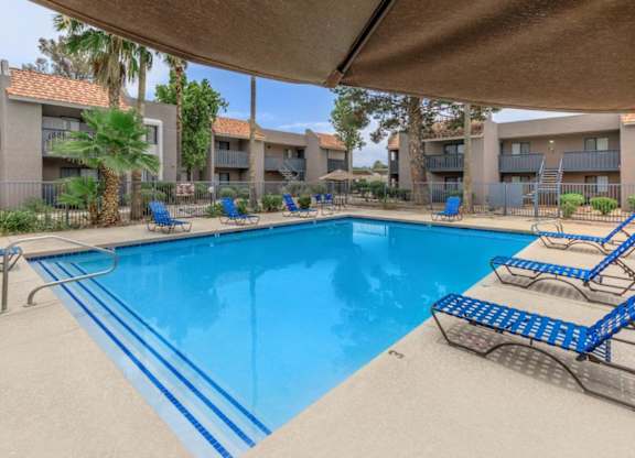 A large swimming pool with blue water and a metal diving board.
