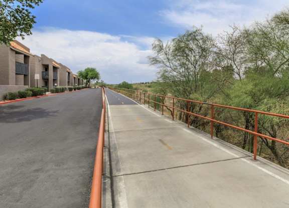 A long road with a metal railing on the side.
