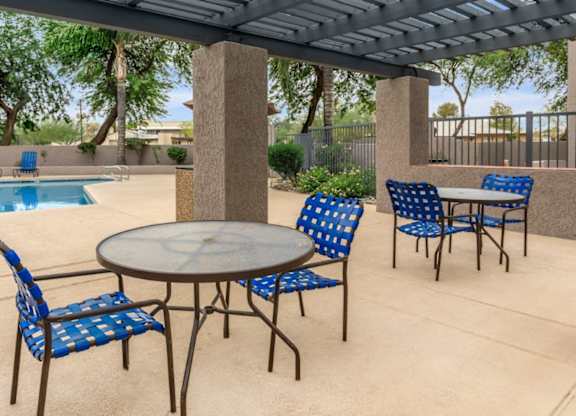 A patio with a table and chairs under a roof.