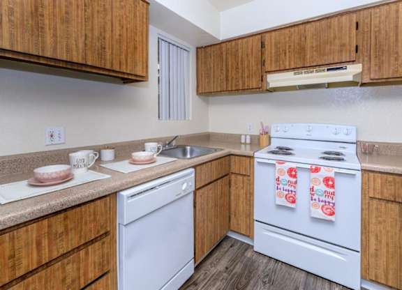 A kitchen with wooden cabinets and white appliances.