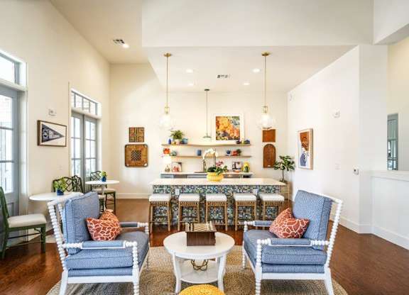 A living room with a blue chair and a white chair.