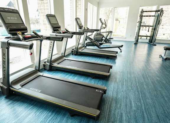 A gym with treadmills and elliptical machines.
