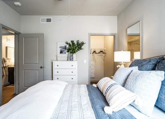 A bedroom with a large bed and a white dresser.
