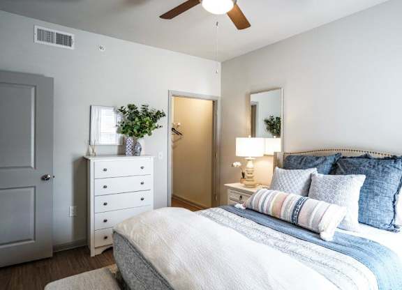 A bedroom with a bed, dresser, and mirror.