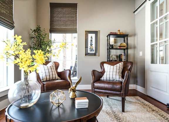 A living room with a brown leather chair and a black coffee table.