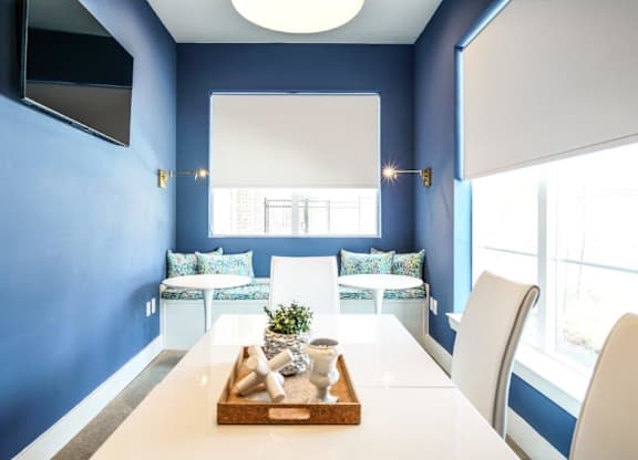 A dining room with a white table and chairs.