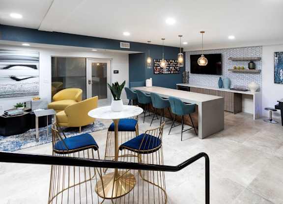 A modern dining area with a white table and blue chairs.