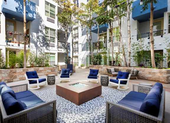 A patio with blue cushions and a stone wall.