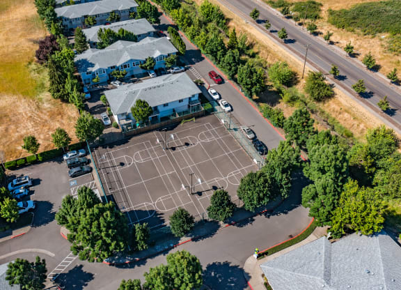 an aerial view of a tennis court in a residential neighborhood