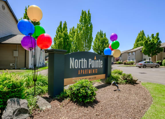 a sign that says north point apartments with balloons in front of it