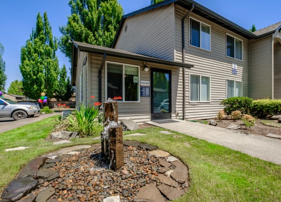 the front of the building with a fountain in the front yard