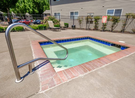 a hot tub sits in the middle of a concrete patio