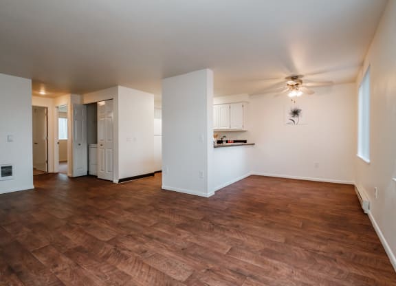 an empty living room with a ceiling fan