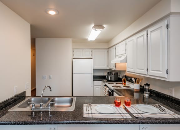 a kitchen with white cabinets and granite countertops