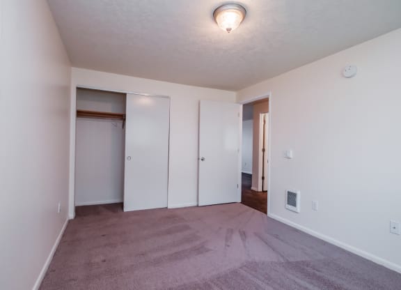 a bedroom with a carpeted floor and white walls