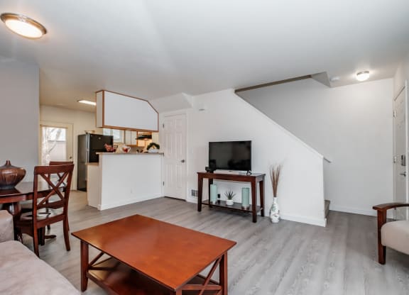 a living room with a tv and a kitchen in the background