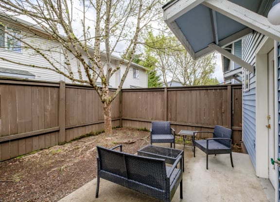 a private patio with a tree and two chairs