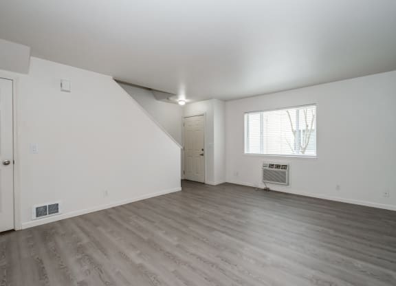 a bedroom with hardwood floors and white walls