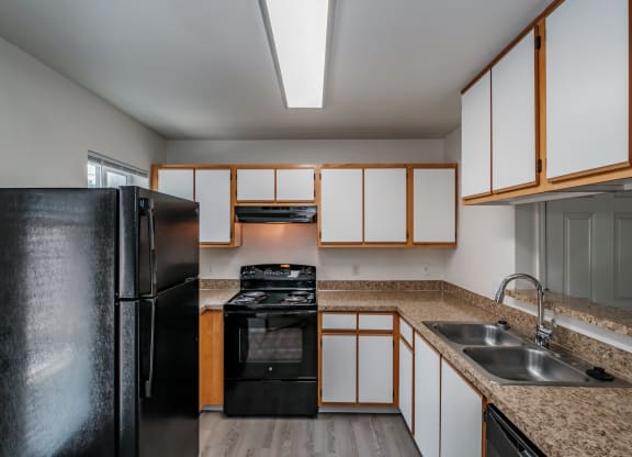 a kitchen with white cabinets and black appliances