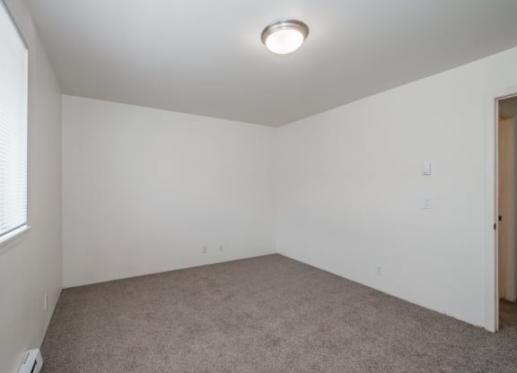 a bedroom with white walls and carpet