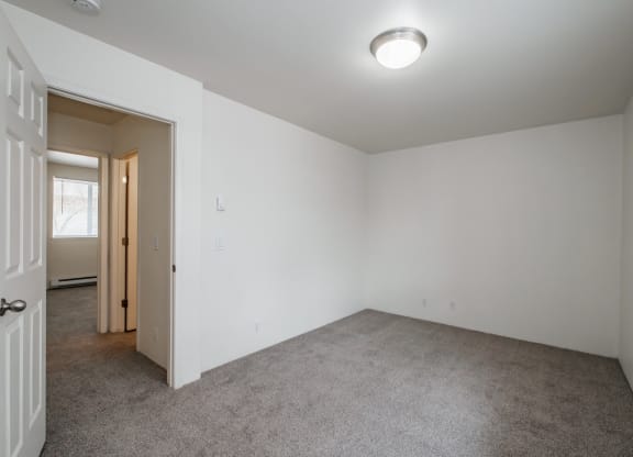 a bedroom with white walls and carpet
