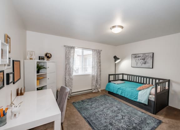 a bedroom with a bed and a desk with a chair