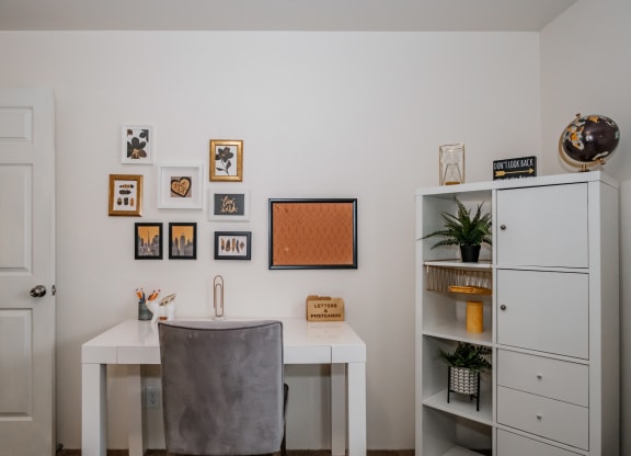 a home office with a white desk and a grey chair