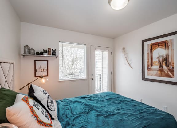 a bedroom with a bed and two windows
