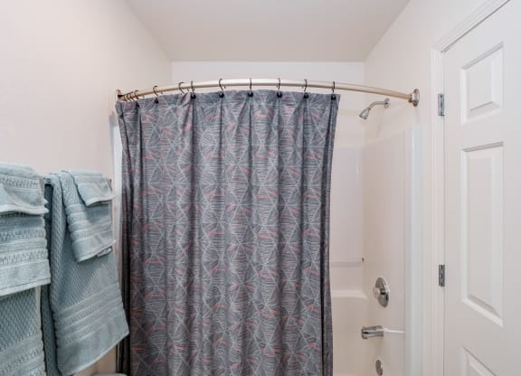 a bathroom with a shower curtain and a white door