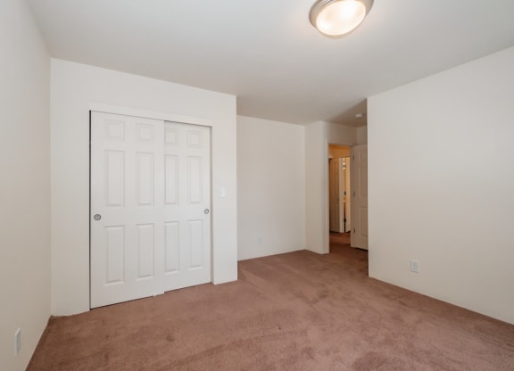 a bedroom with a carpeted floor and a white door