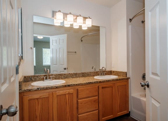 a bathroom with two sinks and a shower
