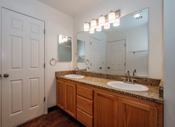 a bathroom with two sinks and a white door