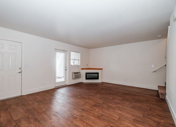 a living room with hardwood floors and white walls