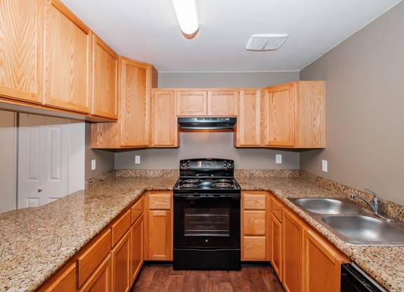 a kitchen with wood cabinets and granite countertops