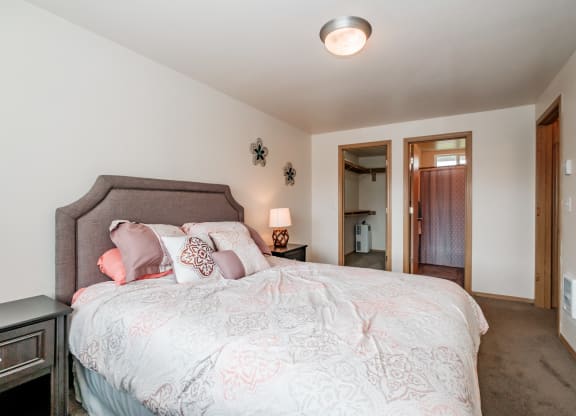 a bedroom with a large bed and a door to a bathroom