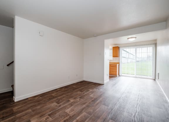 a bedroom with hardwood floors and white walls