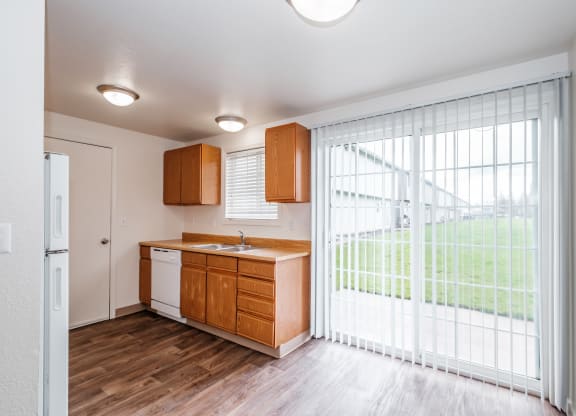 a kitchen with wood flooring and a large sliding glass door