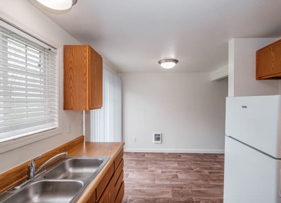 a kitchen with wood cabinets and a stainless steel sink