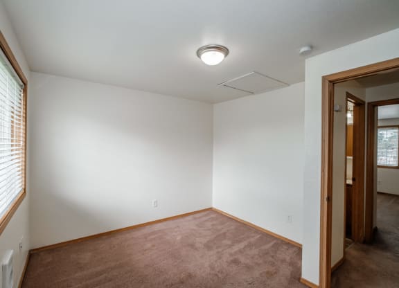 a bedroom with white walls and a carpeted floor