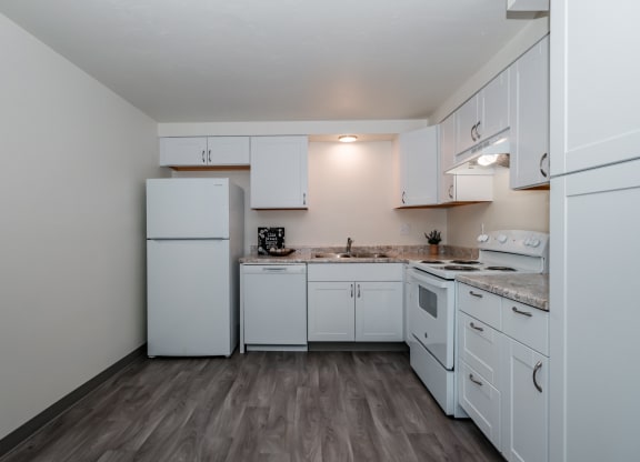 a kitchen with white cabinets and a white refrigerator