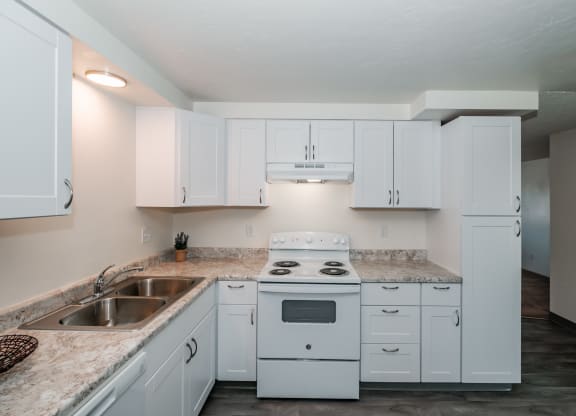 a kitchen with white cabinets and a white stove top oven