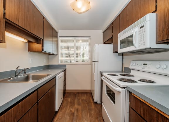 a kitchen with white appliances and wooden cabinets