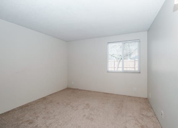 a bedroom with white walls and carpet