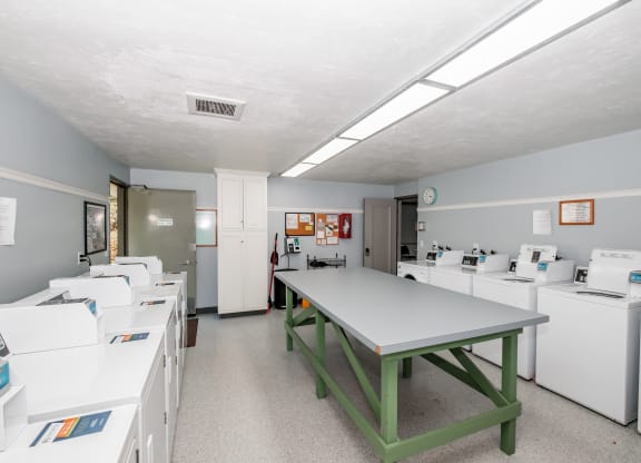 a room with a table and washing machines