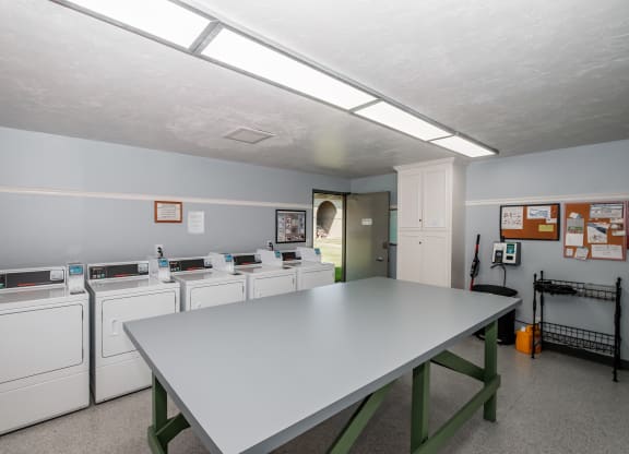 a laundry room with a table and washers and dryers