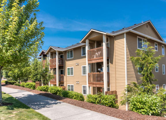 an apartment building with a sidewalk and trees