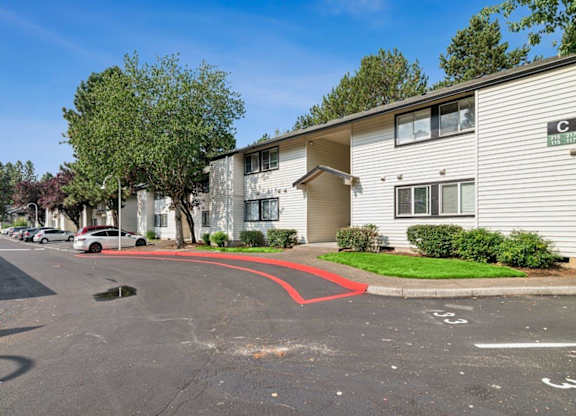 A parking lot in front of a building with a red line painted on the pavement.
