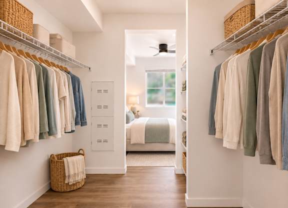 A bedroom with a bed and a closet with clothes hanging.