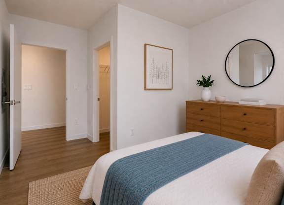 A bedroom with a bed, dresser, and mirror.