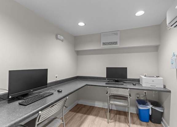 A room with a desk, computer, and monitor.
